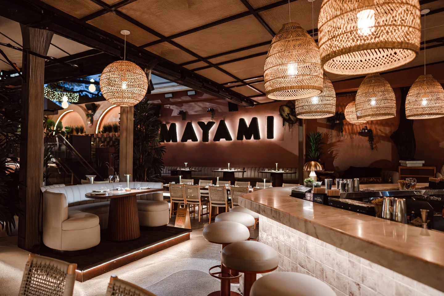 Mayami Wynwood dining room with woven pendant lights and warm wood finishes